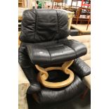 A black leather swivel chair with footstool