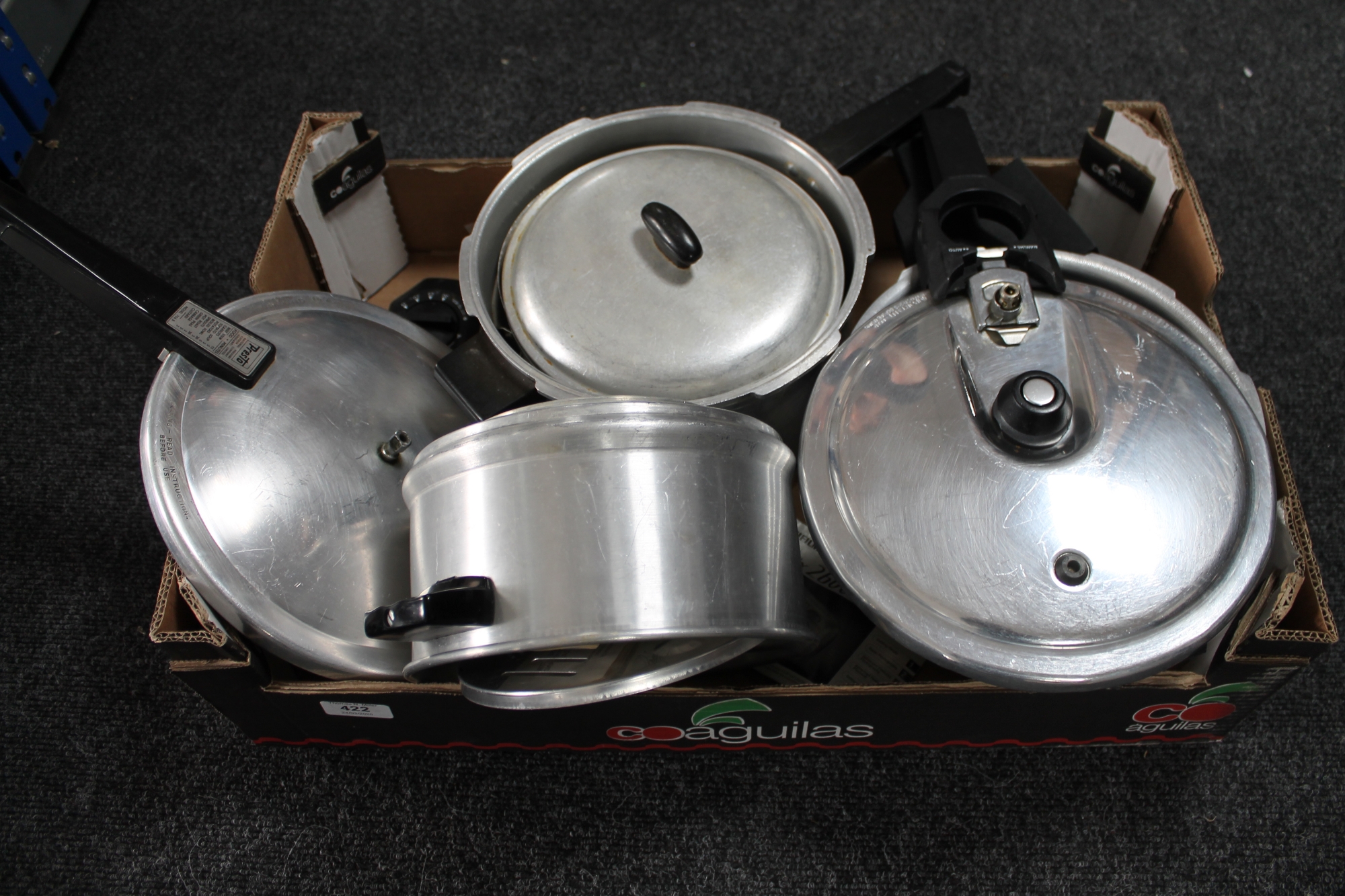 A box of pressure cookers and kitchen ware