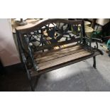A wooden and metal garden bench with footrest