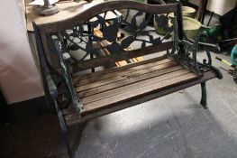 A wooden and metal garden bench with footrest