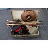 A vintage suitcase containing various clothing, walking sticks,