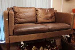 A 20th century Danish brown leather three seater and matching two seater settee