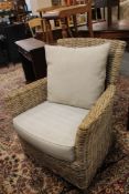 A pair of wicker armchairs with grey cushions