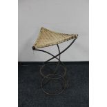 A wrought iron wicker seated stool