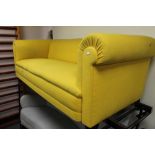 An early twentieth century yellow fabric three seater settee