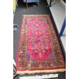 A Persian rug on raspberry ground,