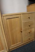 A light oak storage cabinet fitted with four drawers