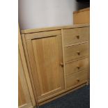 A light oak storage cabinet fitted with four drawers