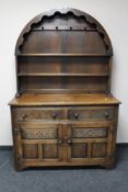 A carved oak dome topped dresser