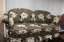 A contemporary three seater settee and pair of matching armchairs in floral three tone fabric