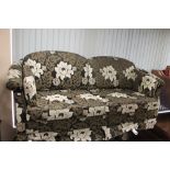 A contemporary three seater settee and pair of matching armchairs in floral three tone fabric