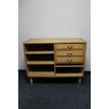 A set of blonde oak shelves fitted three drawers