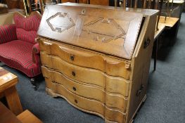 A nineteenth century oak serpentine fronted bureau