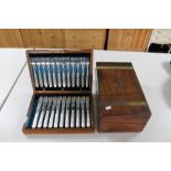 An antique mahogany box containing cutlery together with a wooden writing box