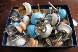 A box of porcelain and wooden drawer knobs