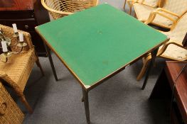 A folding card table together with a wicker chair and a linen basket