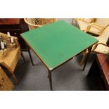 A folding card table together with a wicker chair and a linen basket