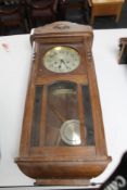 An early 20th century oak wall clock