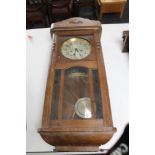 An early 20th century oak wall clock