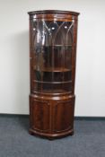 A reproduction mahogany glazed corner cabinet