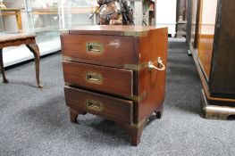 A reproduction mahogany three drawer chest with metal mounts