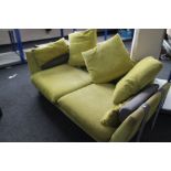 A contemporary peppermint green three seater settee with scatter cushions