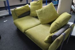 A contemporary peppermint green three seater settee with scatter cushions