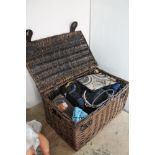 A wicker basket containing a collection of lady's handbags