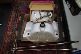 An unplumbed ceramic sink with brass fittings and taps