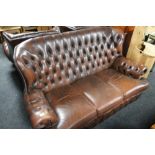 A three piece brown leather chesterfield style lounge suite