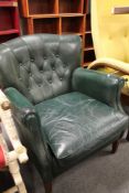 A green buttoned leather mid century armchair