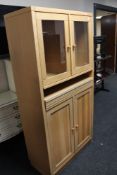 A light oak double door glazed cabinet