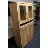 A light oak double door glazed cabinet