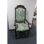 A carved oak armchair with studded tapestry seat