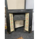 A Victorian cast iron fire insert with tiled surround