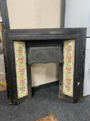 A Victorian cast iron fire insert with tiled surround