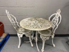 An antique style painted metal patio table and two chairs