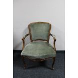 An antique style carved walnut armchair in green fabric