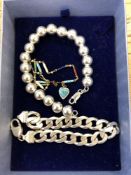 A silver bead bracelet, an enamelled bracelet and a silver curb link bracelet.