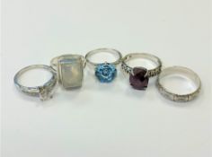 Five silver dress rings.