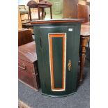 A painted bow fronted corner cabinet
