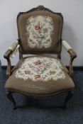 A carved walnut armchair with tapestry covering