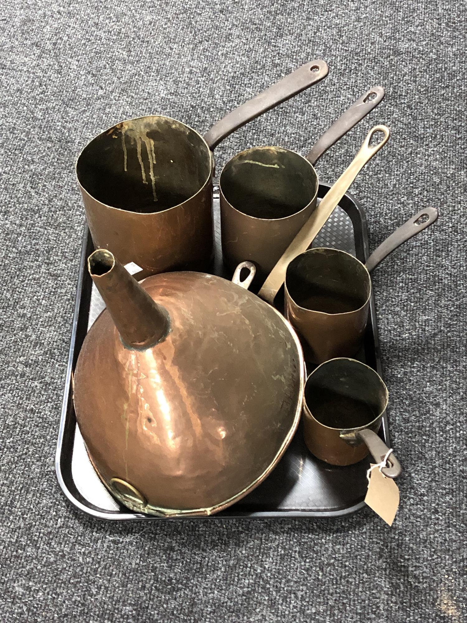 A tray of metal ware, large copper funnel, copper skillets,