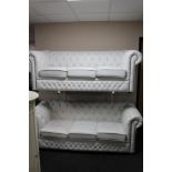 A pair of white studded leather three seater Chesterfield style settees