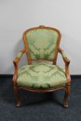 A Continental carved walnut armchair in green fabric