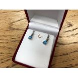 A pair of blue topaz and diamond earrings set with diamonds.