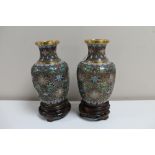 A pair of cloisonne vases on wooden stands, height 14.
