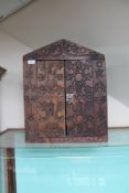 A carved wooden wall cabinet