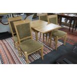 A contemporary dining room table together with four chairs in light oak finish