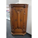 A continental carved oak corner cabinet